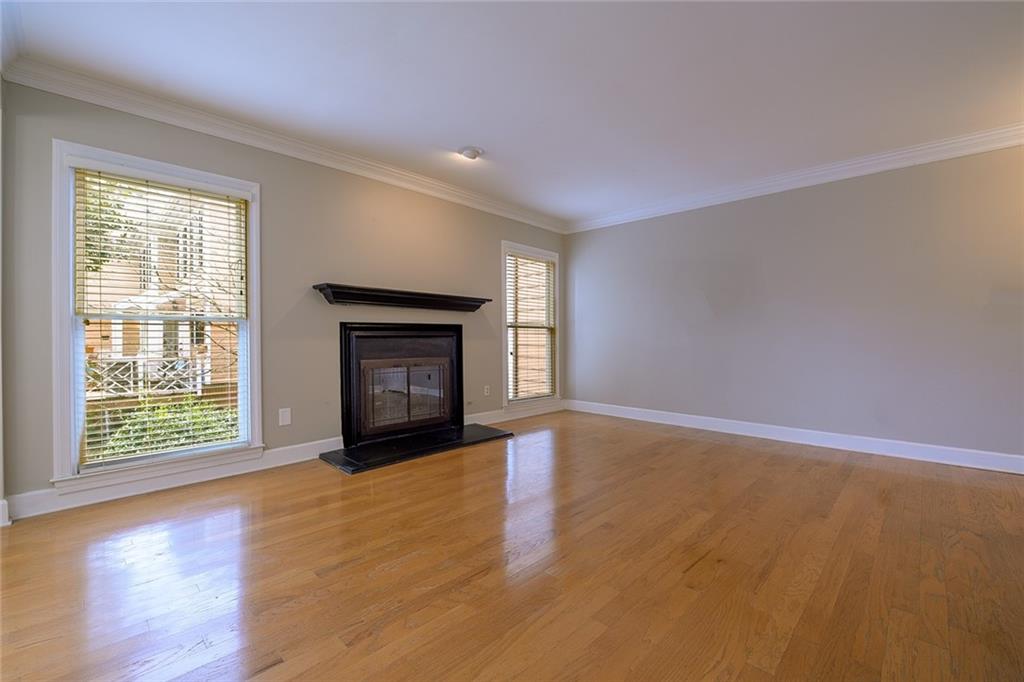 Unfurnished living room featuring plenty of natural light, ornamental molding, and light hardwood / wood-style floors