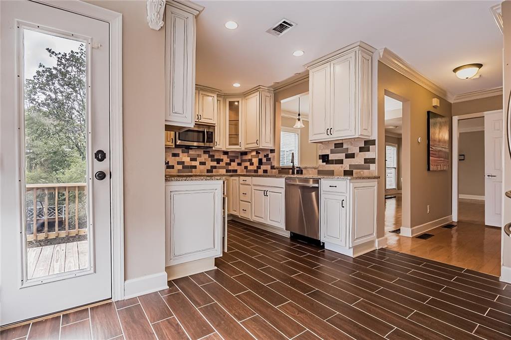 Kitchen with appliances with stainless steel finishes, tasteful backsplash, and a healthy amount of sunlight