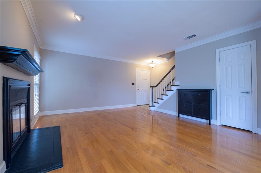 Unfurnished living room featuring light hardwood / wood-style flooring and crown molding