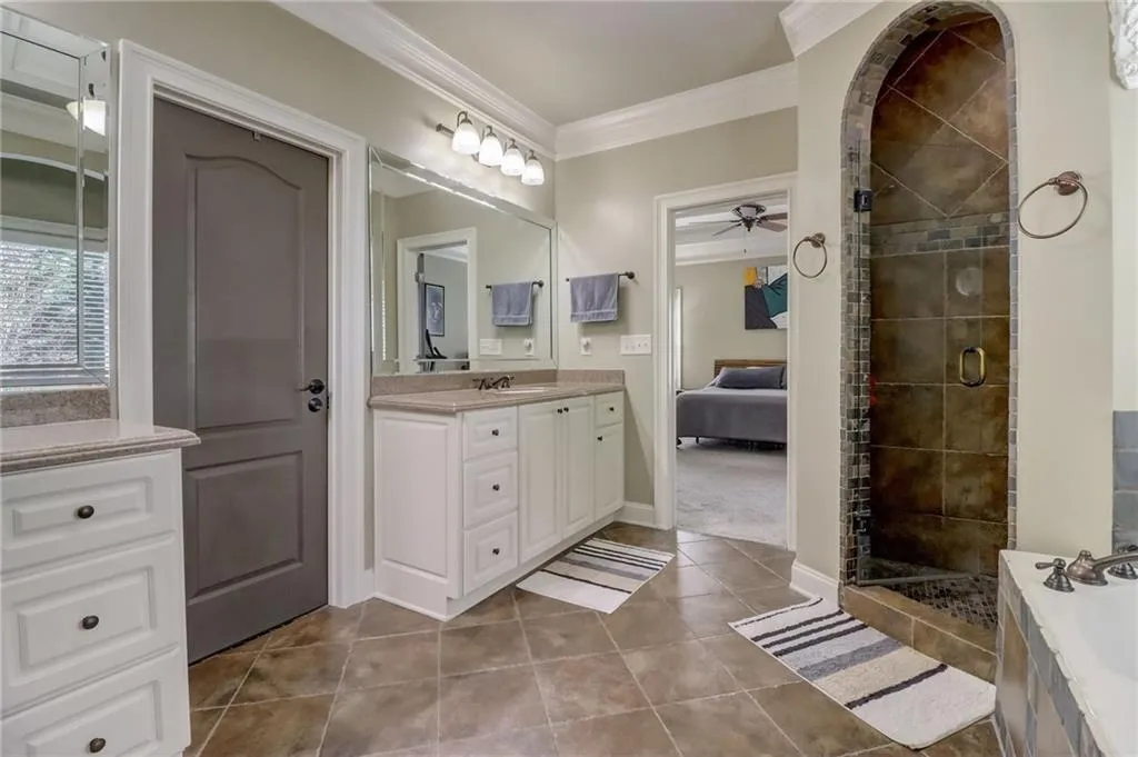 Bathroom featuring tile flooring, ceiling fan, and shower with separate bathtub
