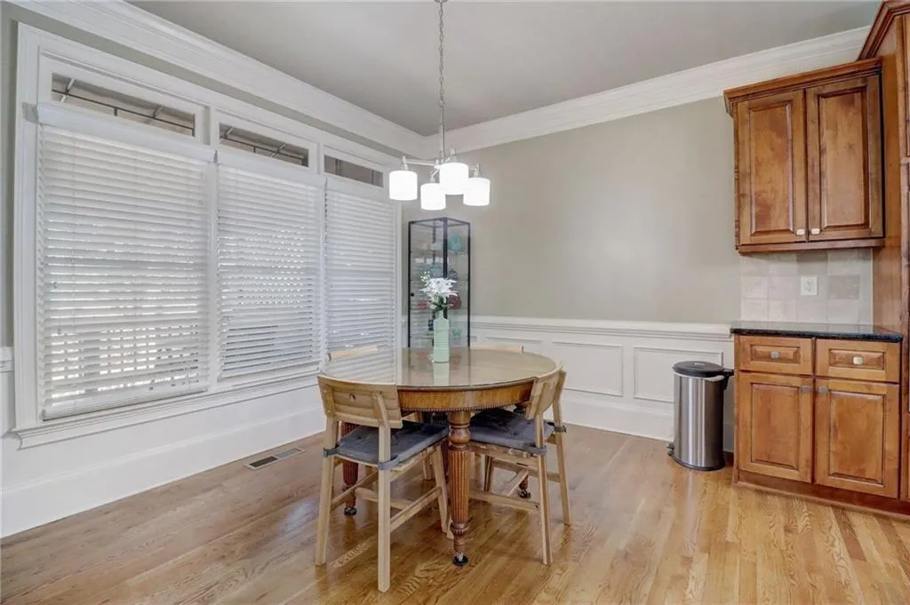 Dining room with a notable chandelier, ornamental molding, and light hardwood / wood-style floors