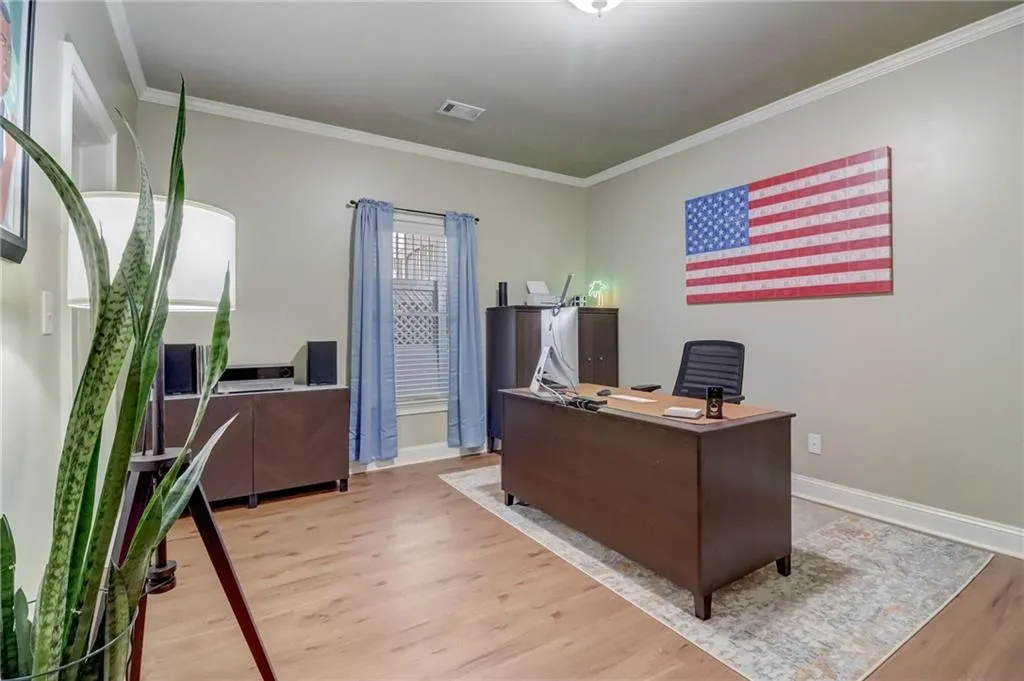 Home office with ornamental molding and hardwood / wood-style floors