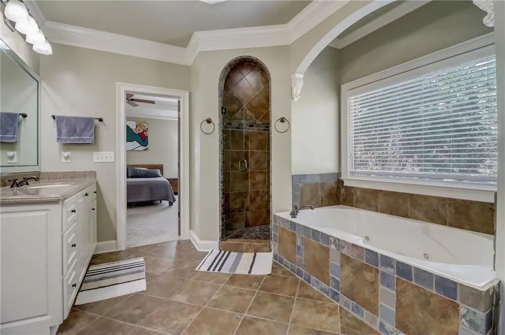 Bathroom featuring independent shower and bath, oversized vanity, tile flooring, and crown molding