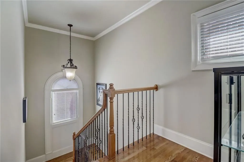 Stairs featuring crown molding and wood-type flooring
