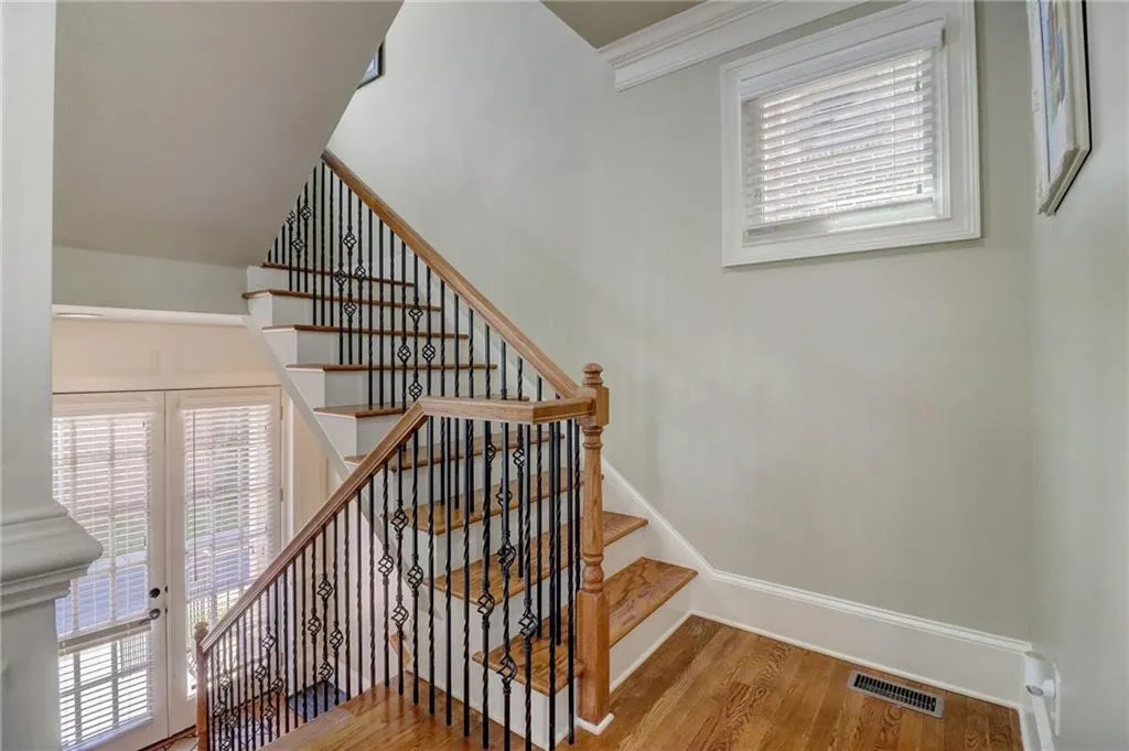 Stairs featuring french doors, a wealth of natural light, and hardwood / wood-style floors