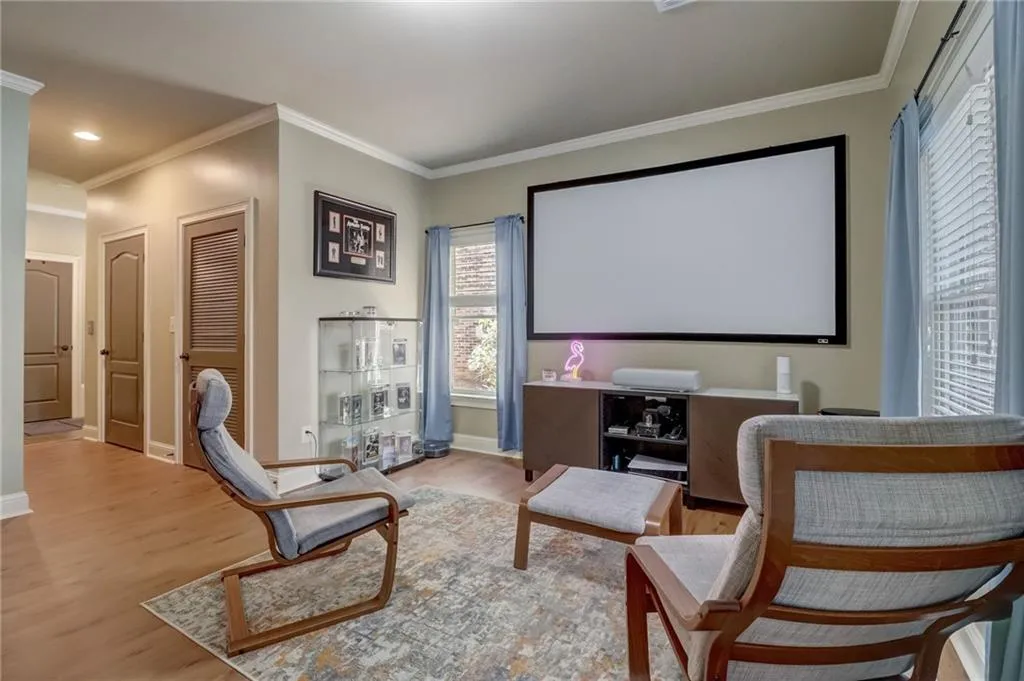 Cinema room featuring hardwood / wood-style flooring and crown molding