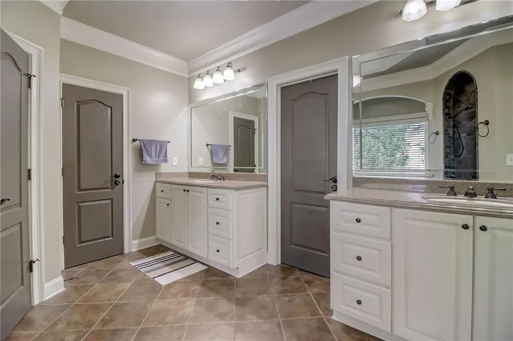 Bathroom with tile flooring, oversized vanity, and crown molding