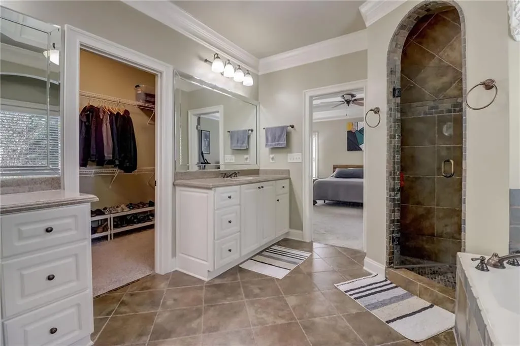 Bathroom with shower with separate bathtub, ceiling fan, and tile floors