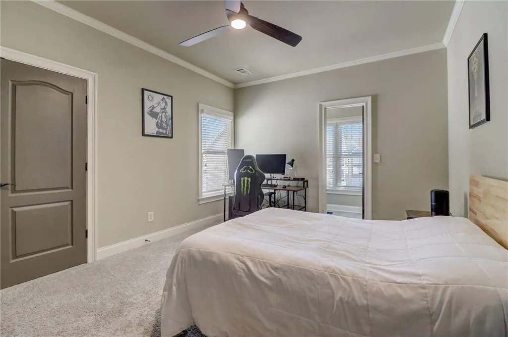 Bedroom featuring crown molding, carpet floors, and ceiling fan