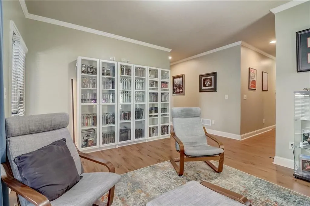 Living area featuring wood-type flooring and crown molding