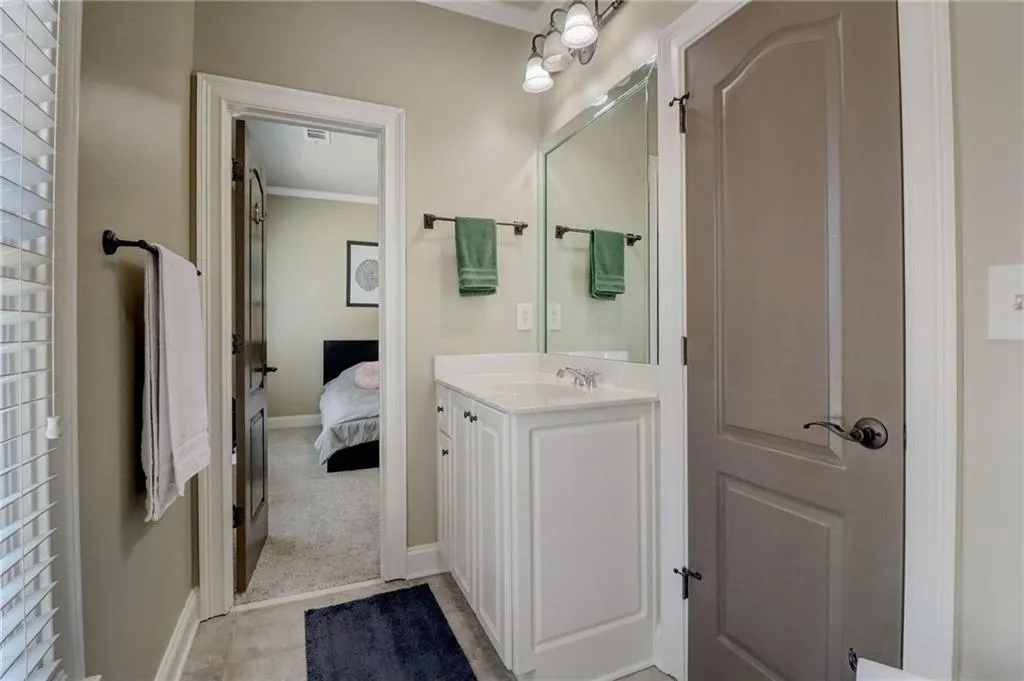 Bathroom featuring crown molding, tile flooring, and large vanity