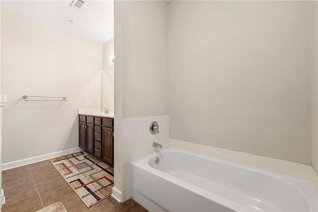 Bathroom featuring tile floors, vanity, and a bath