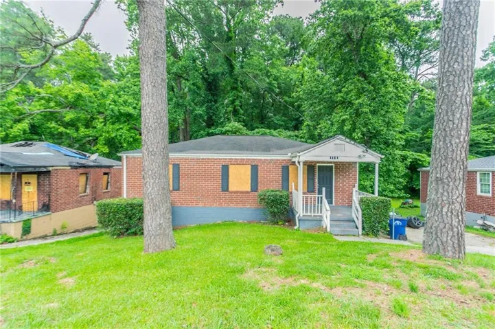 View of front of property featuring brick siding and a front lawn