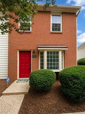 END UNIT,brick exterior with an accenting red door, bay window, and white window frames