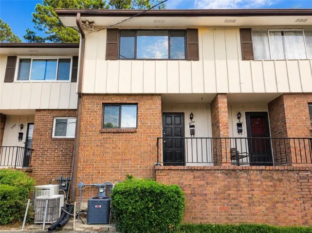 Brick and vertical siding exterior with brown shutters