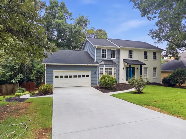 Two-story residence featuring a two-car garage with transom windows