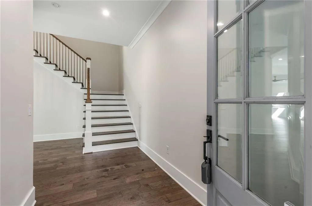 Foyer with stairs, dark wood-style flooring, and recessed lighting
