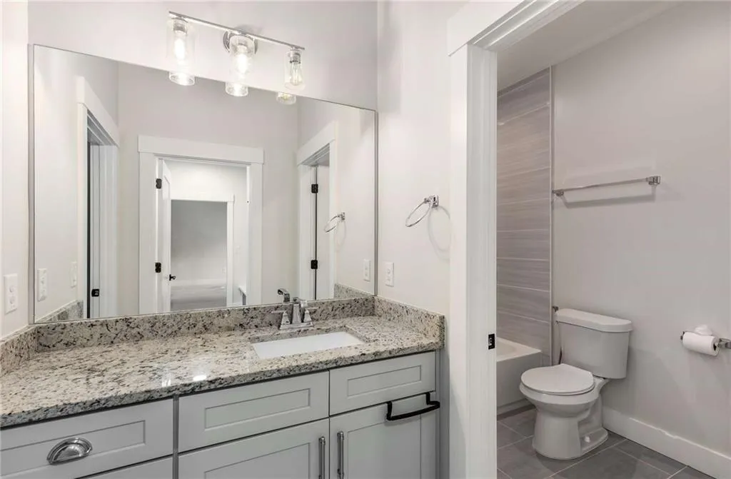 Full bathroom featuring vanity, dark tile patterned floors, and shower / washtub combination