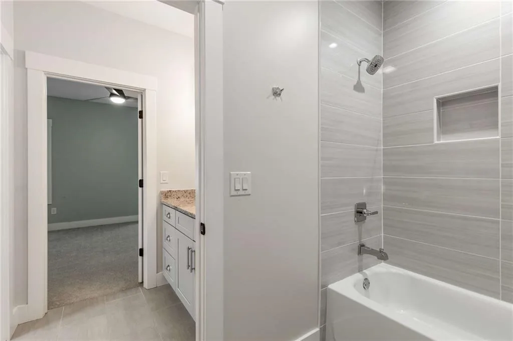 Bathroom with shower / bathtub combination, vanity, light tile patterned floors, and light carpet