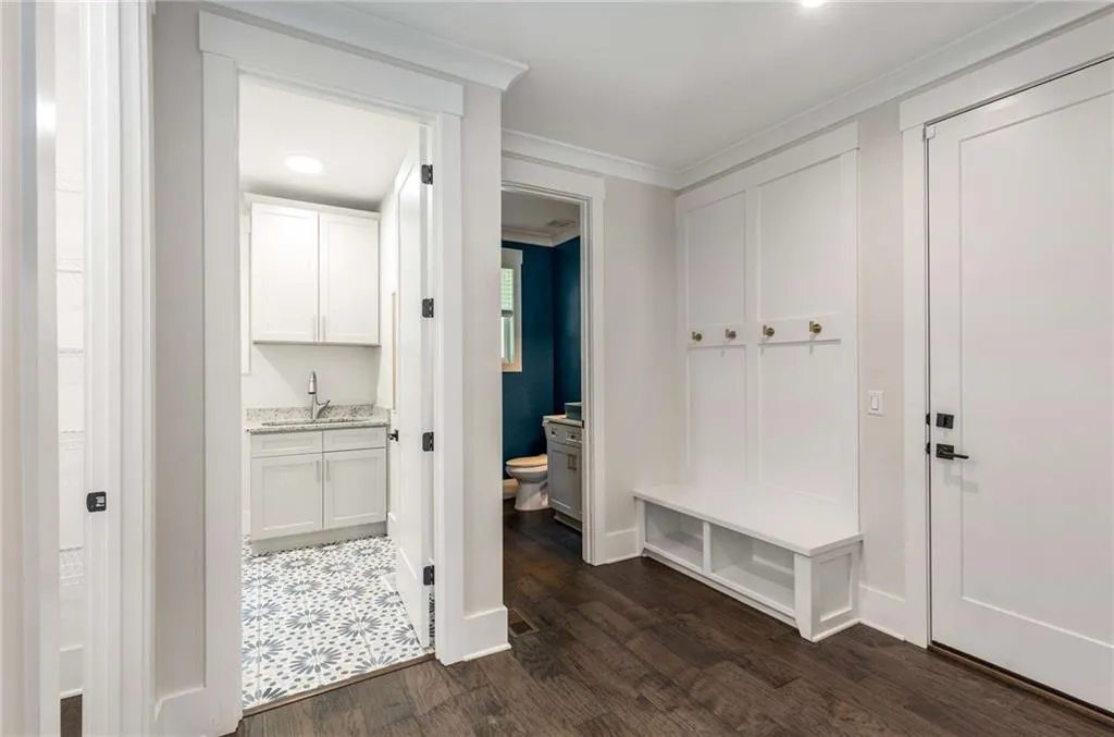 Mudroom with dark wood-style floors, ornamental molding, and recessed lighting