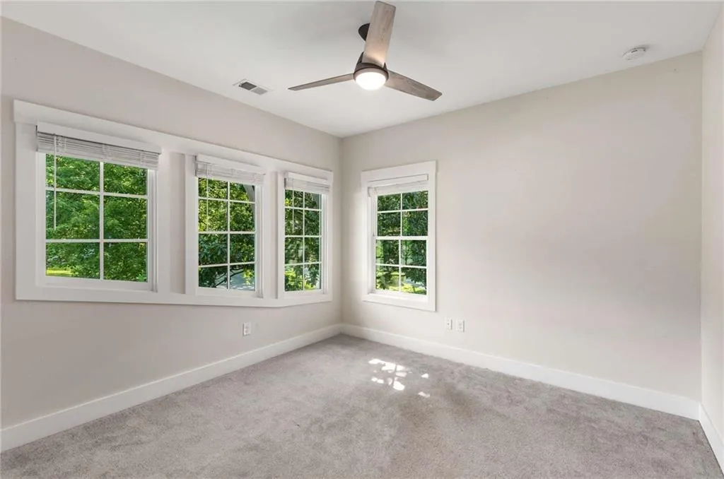 Carpeted empty room featuring baseboards and ceiling fan