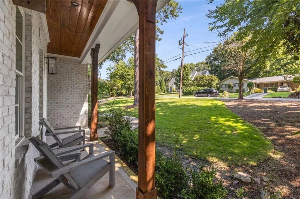 View of grassy yard featuring covered porch