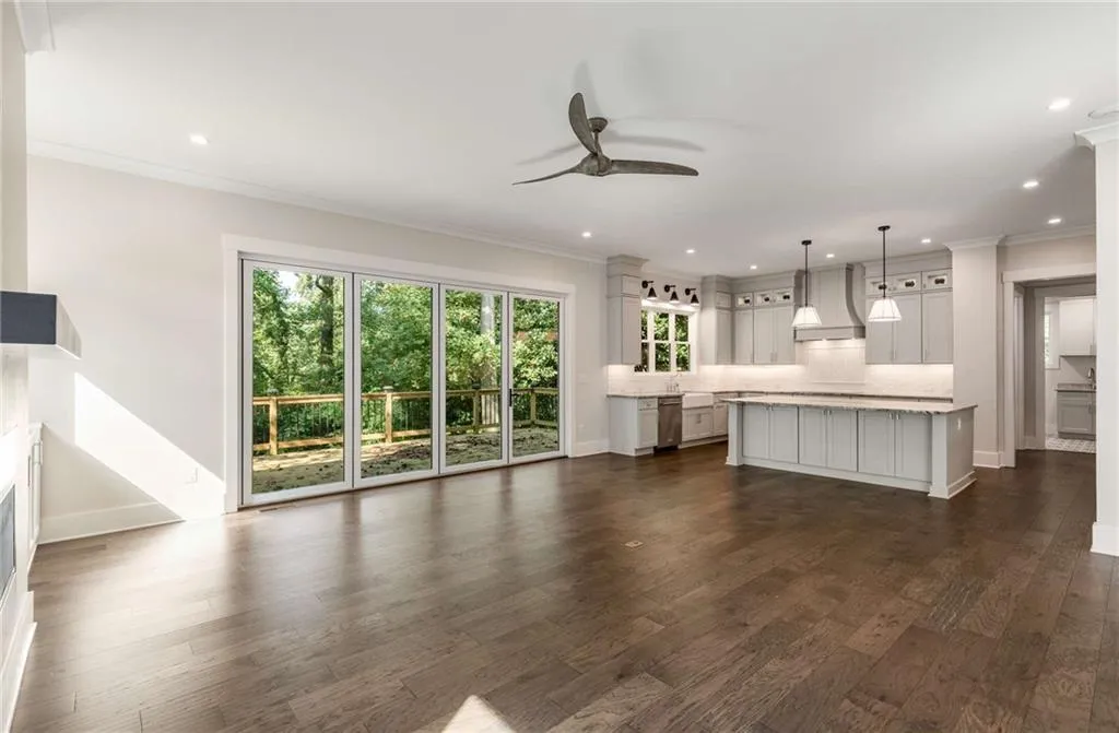 Unfurnished living room featuring crown molding, ceiling fan, dark wood-style flooring, and recessed lighting