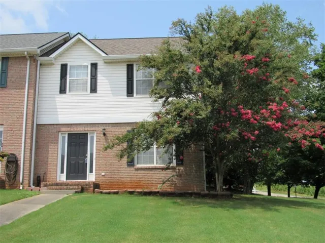 Brick and siding exterior with a dark entry door featuring sidelight windows
