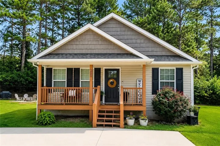 Craftsman-style exterior with a covered front porch, horizontal siding, and shake siding accents
