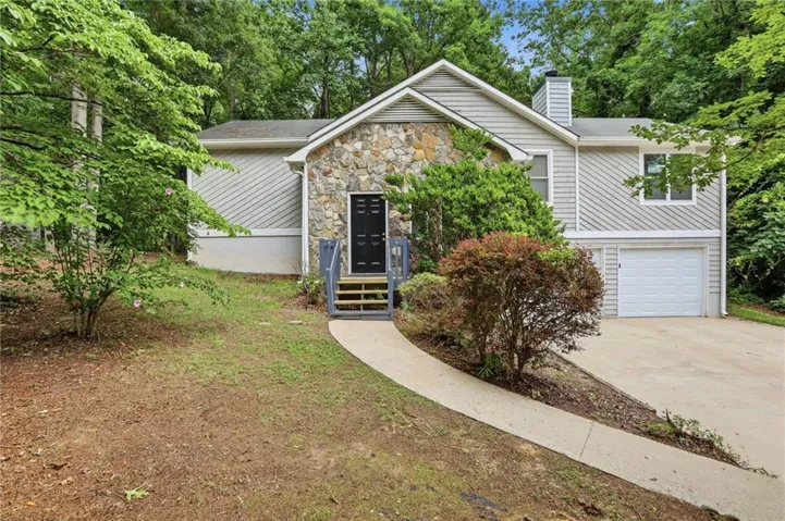 Exterior featuring stone accents, horizontal siding, and a prominent front entry with steps