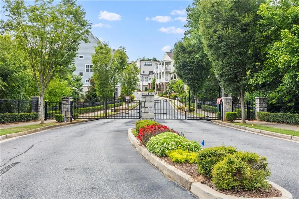 View of street featuring a gated entry, a gate, and curbs