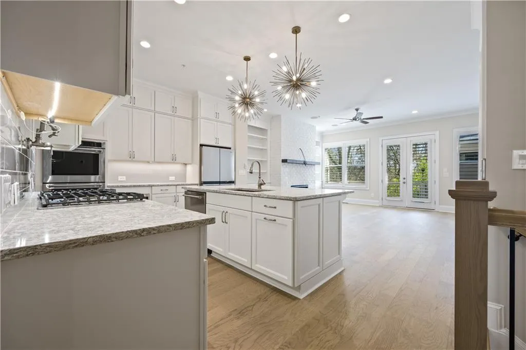 Kitchen featuring white cabinets, light wood finished floors, stainless steel appliances, recessed lighting, and a sink