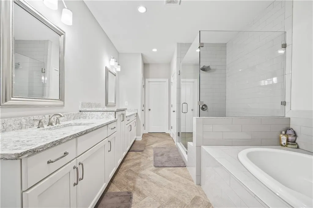 Primary Bathroom with a shower stall, recessed lighting, vanity, and a garden tub
