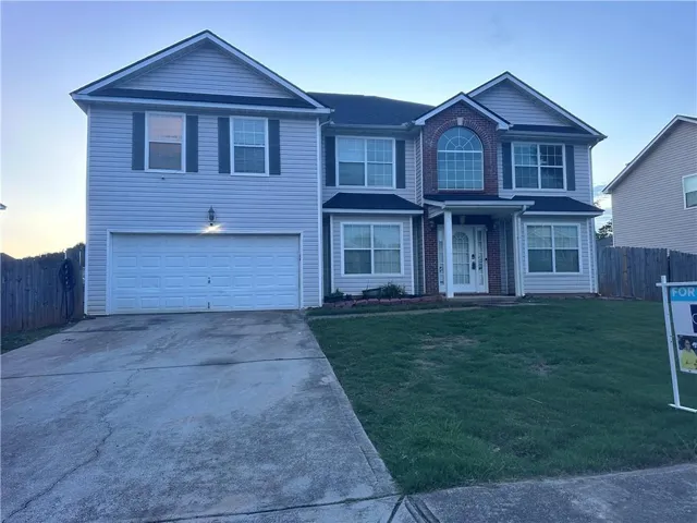 Two-story home with light-colored siding and dark shutters