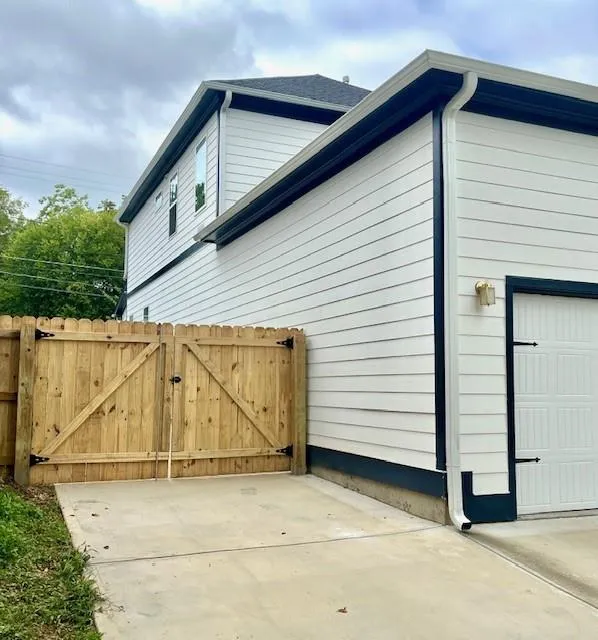 View of side of home with a gate