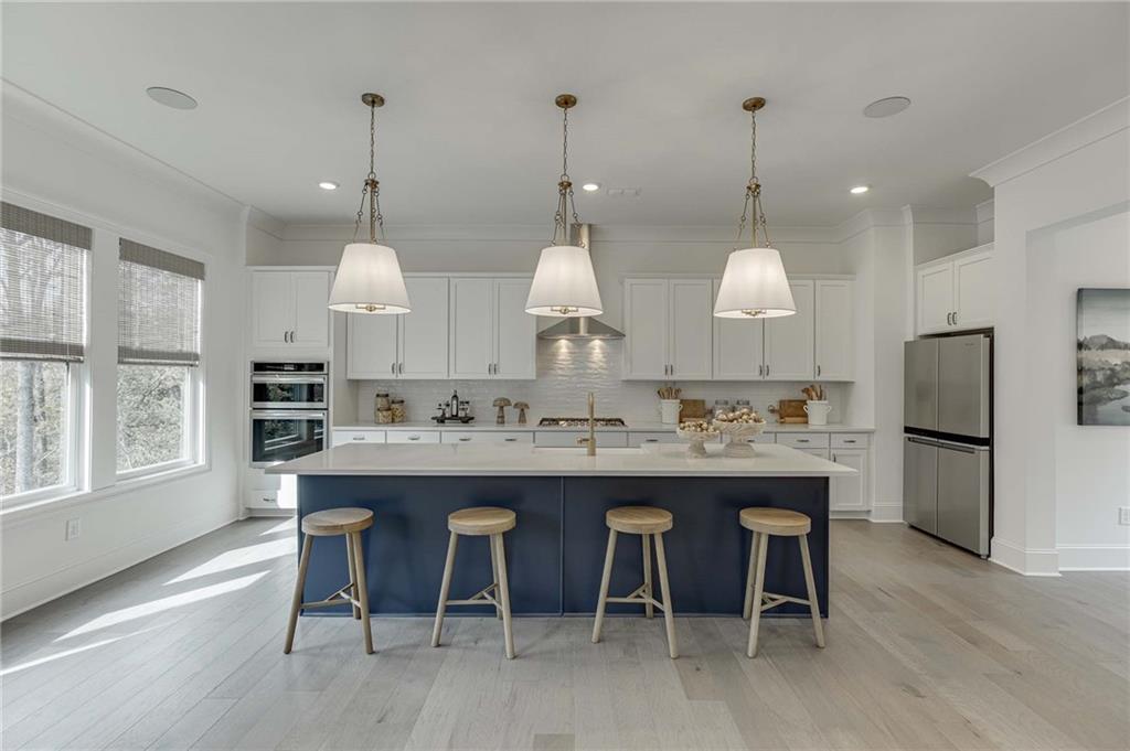 The kitchen offers a spacious quartz island with pendant lighting.