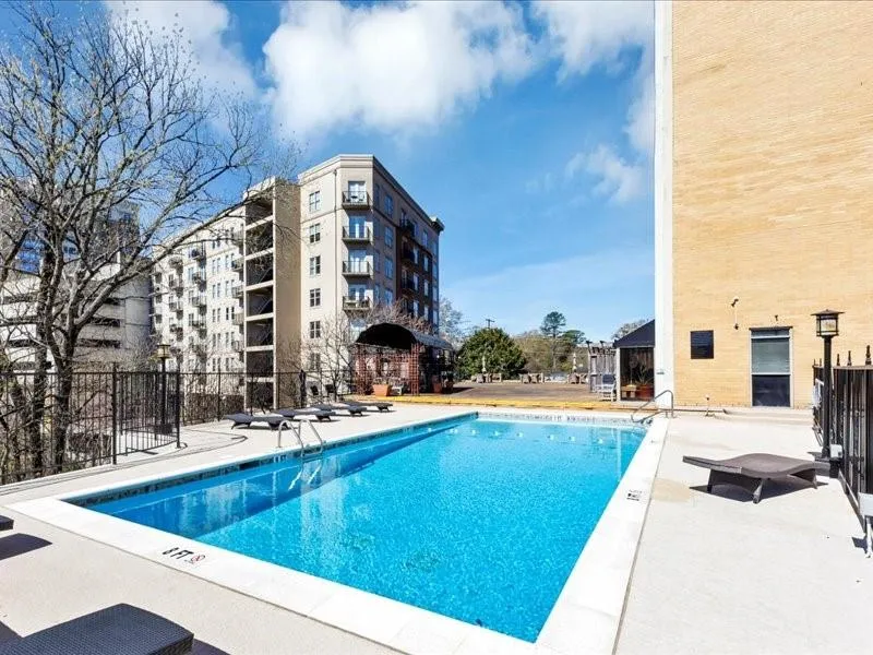 Community pool with a patio and fence