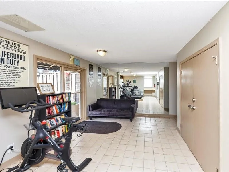Exercise room with light tile patterned flooring