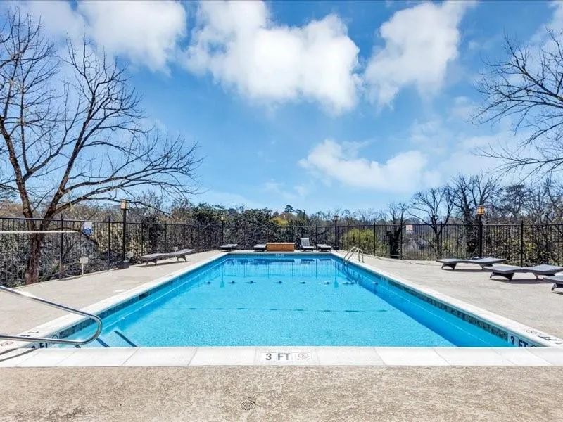 Pool with a patio area and fence