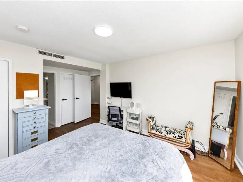 Bedroom featuring visible vents, baseboards, and wood finished floors