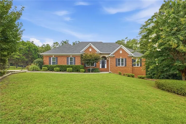 Brick exterior with dark shutters, gabled rooflines, and mature landscaping