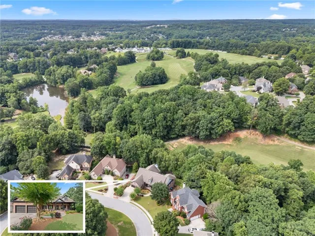 Aerial perspective showcasing a residential area with a prominent golf course and a natural pond