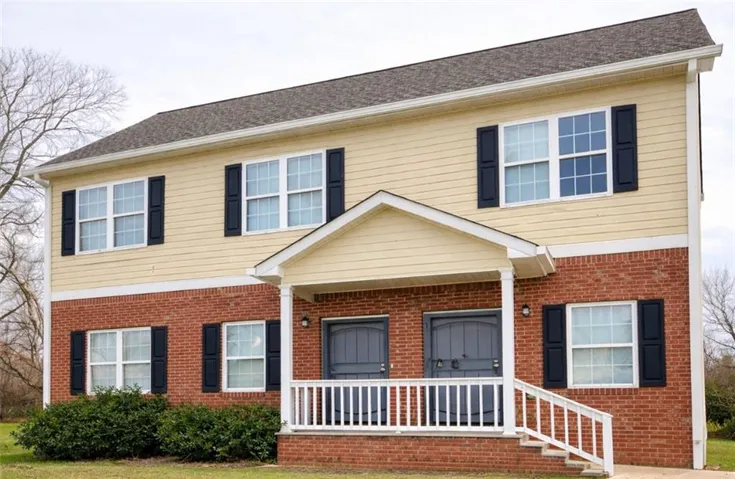 Two-story multi-unit dwelling with a brick first level and horizontal siding on the second level
