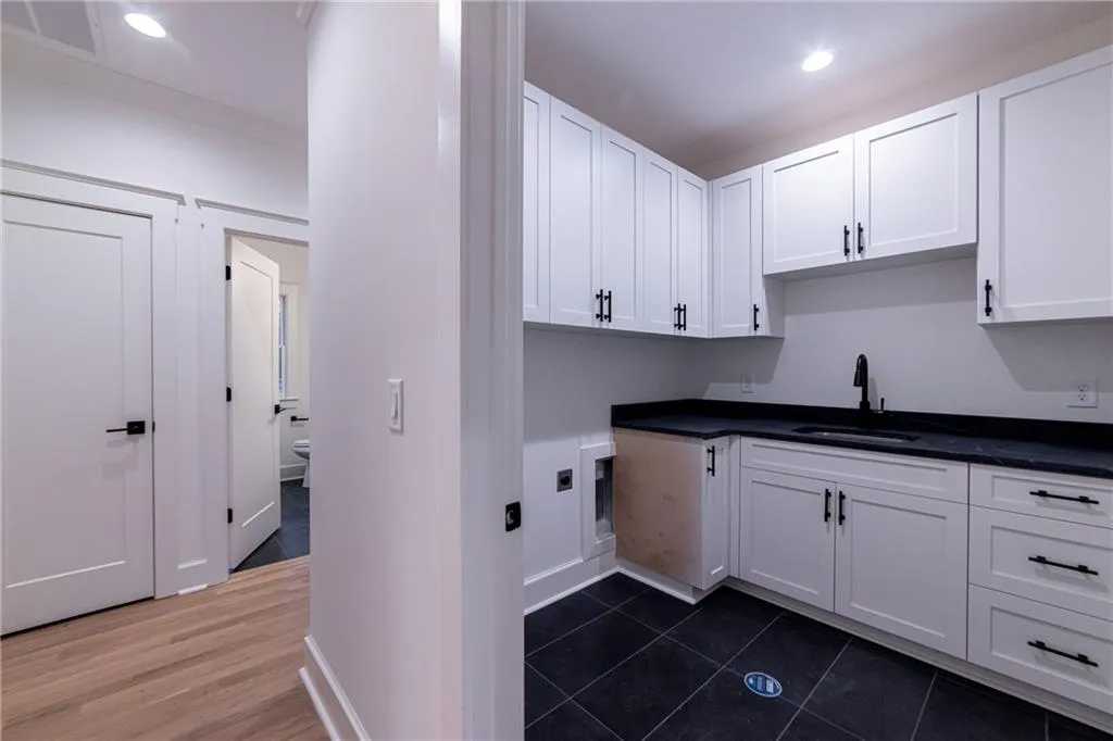 Washroom with cabinet space, recessed lighting, and dark tile patterned flooring