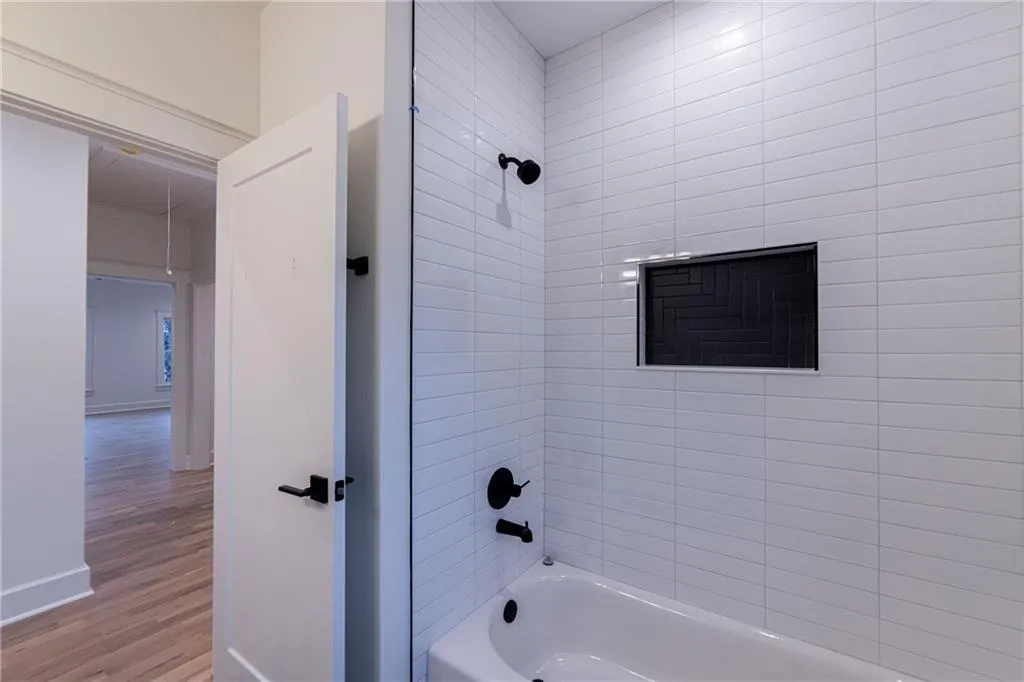 Bathroom featuring shower / washtub combination and wood finished floors