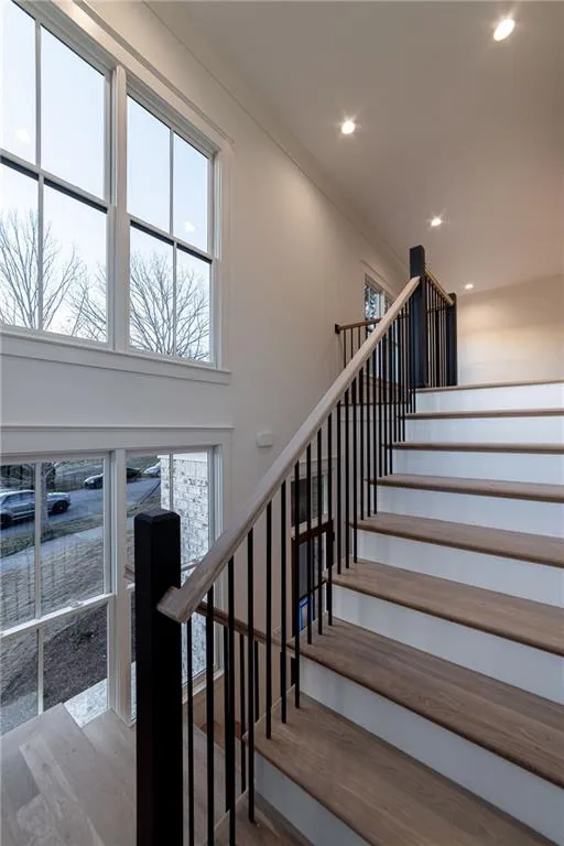 Staircase featuring wood finished floors and recessed lighting