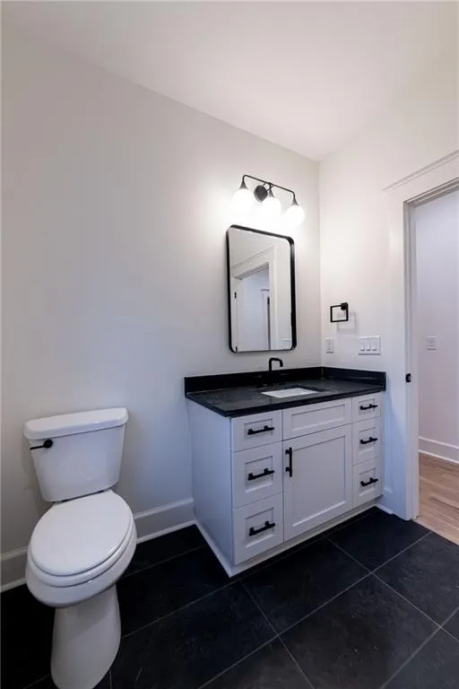 Half bathroom featuring vanity and tile patterned flooring