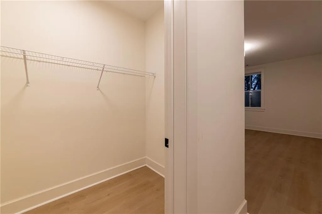 Walk in closet with light wood-type flooring
