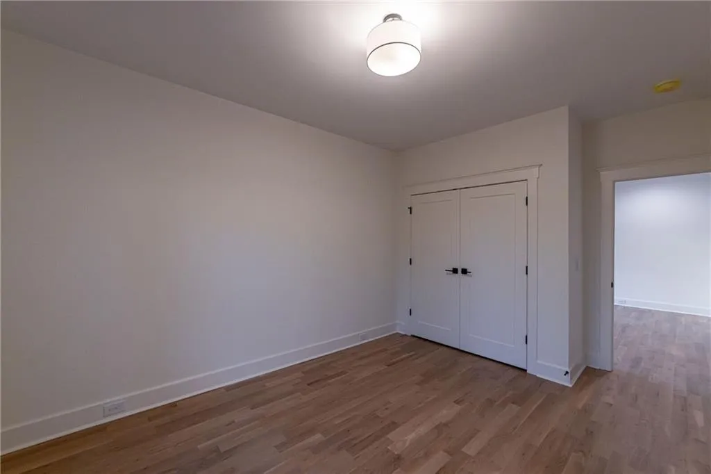 Unfurnished bedroom featuring wood finished floors and a closet