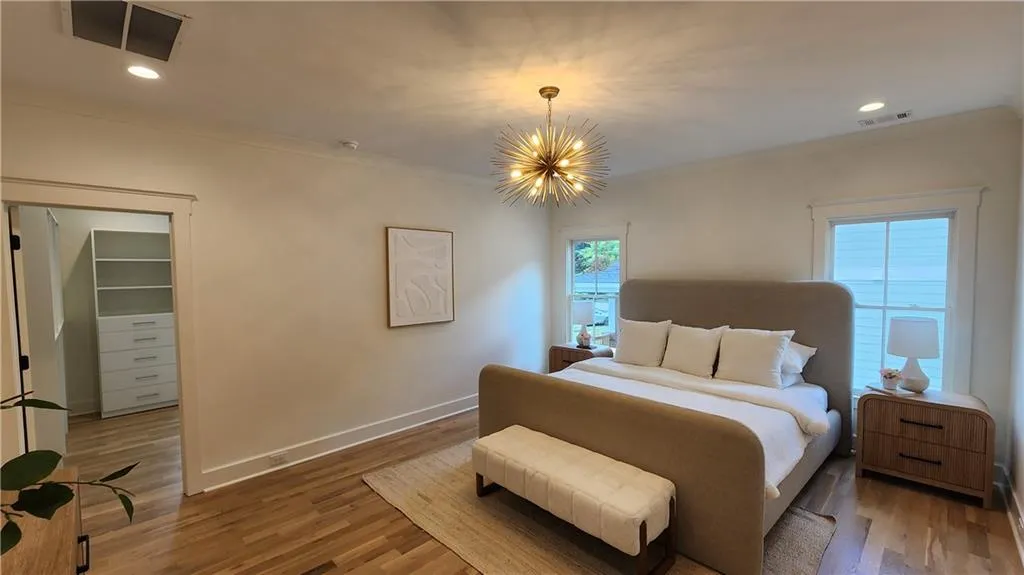 Bedroom featuring wood finished floors, recessed lighting, a chandelier, and ornamental molding